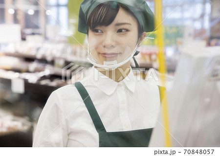 感染対策をしたスーパーのレジで仕事をする女性従業員 シート越し 感染対策をしたスーパーのレジで仕事をする女性従業員 シート越し 70848057