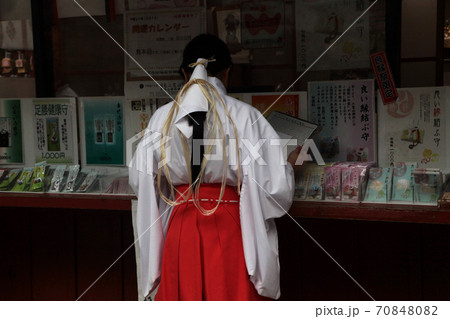 日光二荒山神社の社務所窓口で参拝記念品の整理をする巫女さん 70848082