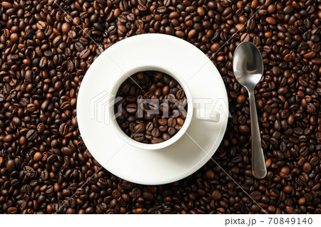 Cup and spoon on coffee beans background, top view Cup and spoon on coffee beans background, top view 70849140