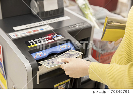 スーパーの自動精算機で支払いをする女性買い物客 70849791