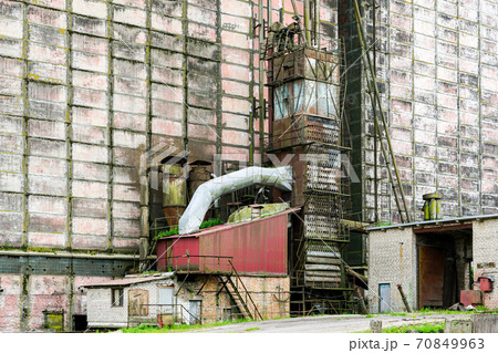 old factory building wall with auxiliary buildings and various pipes 70849963