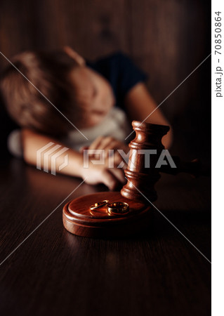 Divorce concept. Wooden gavel, rings and sad boy with teddy bear. Family divorce effect on children Divorce concept. Wooden gavel, rings and sad boy with teddy bear. Family divorce effect on children 70850864