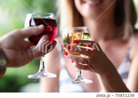 Man and a woman are holding glasses of red and white wine. Man and a woman are holding glasses of red and white wine. 70851236