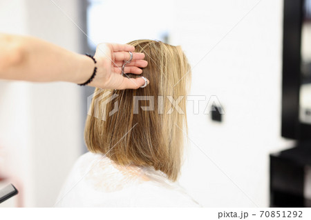 Woman in hairdressing salon cuts her hair 70851292