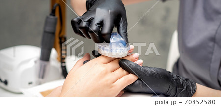 Manicurist brushing dust from fingernails Manicurist brushing dust from fingernails 70852580
