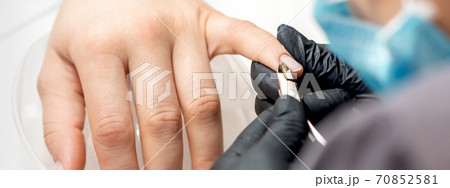 Manicure master removes cuticles by nail clipper Manicure master removes cuticles by nail clipper 70852581