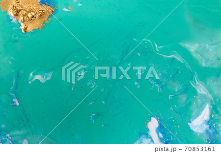Piles of gold sequins on blue smudges of paint. Abstract pattern. 70853161