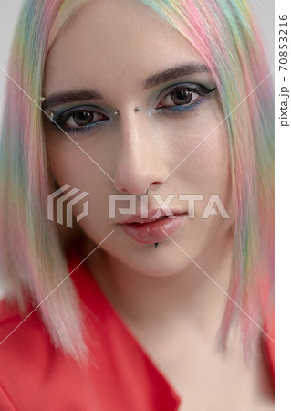 Portrait of a young beautiful informal blonde girl with dyed hair. Red jacket suit on the naked body. Studio photoshoot on a white background. Portrait of a young beautiful informal blonde girl with dyed hair. Red jacket suit on the naked body. Studio photoshoot on a white background. 70853216