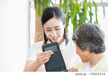 シニア女性と介護士　血圧を測る介護士 70854244