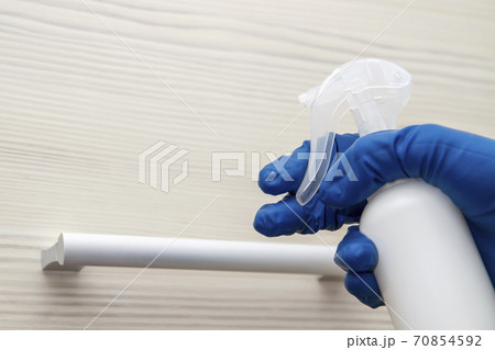 A human hand in a protective glove disinfects the shelf handle for viruses prevention 70854592