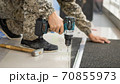 drill in a man's hand close-up on a light background 70855973