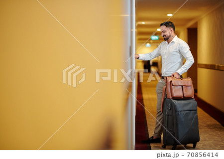 Hotel guest opening room door 70856414