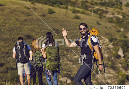 A group of hikers with backpacks are walking along the hill in the mountains in nature. A group of hikers with backpacks are walking along the hill in the mountains in nature. 70856692