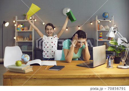 Work at home is stressful. Tired mother with stress working with a laptop at home. 70856791