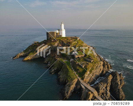 Misty Multicoloured Sky A Lighthouse That Stands On Its Own Against The Great Blue Ocean 70859289