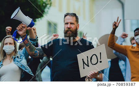 People with placards and posters on public demonstration, no covid vaccine and coronavirus concept. 70859387