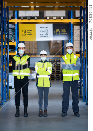 Group of workers with face mask standing in warehouse, coronavirus concept. 70859411