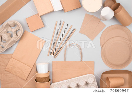 Set of eco-friendly tableware - kraft paper food packaging on light grey background. Street food and fast food paper packaging - cups, plates, straws, containers and paper bags. Flat lay, copyspace Set of eco-friendly tableware - kraft paper food packaging on light grey background. Street food and fast food paper packaging - cups, plates, straws, containers and paper bags. Flat lay, copyspace 70860947