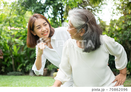 An old elderly Asian woman and exercise in the backyard with her daughter. Concept of happy retirement With care from a caregiver and Savings and senior health insurance, Happy family An old elderly Asian woman and exercise in the backyard with her daughter. Concept of happy retirement With care from a caregiver and Savings and senior health insurance, Happy family 70862096