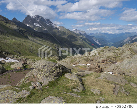 Summer view of Stubai valley from Bremer Hutte at hiking trail, Stubai Hohenweg, rock, boulders and moutain peaks. Tyrol Alps, Austria Summer view of Stubai valley from Bremer Hutte at hiking trail, Stubai Hohenweg, rock, boulders and moutain peaks. Tyrol Alps, Austria 70862786