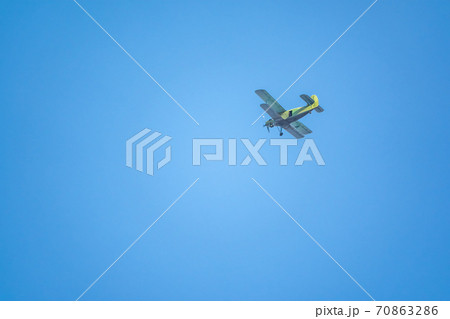 Retro green biplane plane in the blue sky Retro green biplane plane in the blue sky 70863286