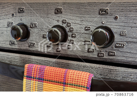 fragment of the front panel of a household gas kitchen stove with switches 70863716