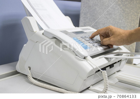 hand man are using a fax machine in the office, equipment for data transmission. hand man are using a fax machine in the office, equipment for data transmission. 70864133