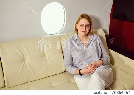 White young woman in airplane business class. 70864264