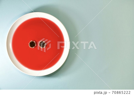 Two eyes of mould fungus, on a plate of fruit tea. Left on a mint colored background. Two eyes of mould fungus, on a plate of fruit tea. Left on a mint colored background. 70865222