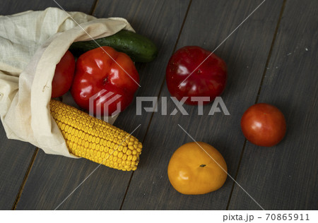 Zero waste concept. Pepper, tomato, corn, cucumber in reusable shopping eco friendly cotton fabric bags. Vegetables in eco bag on a wooden table. Plastic free concept. 70865911