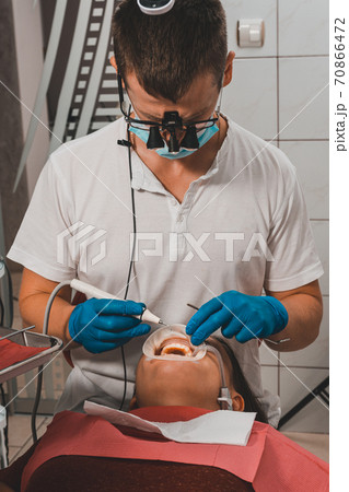 The dentist removes tartar using ultrasound, the patient at the dentist. 70866472