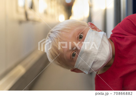 Boy in protective mask rides train compartment. Traveling during a quarantine. Boy in protective mask rides train compartment. Traveling during a quarantine. 70866882