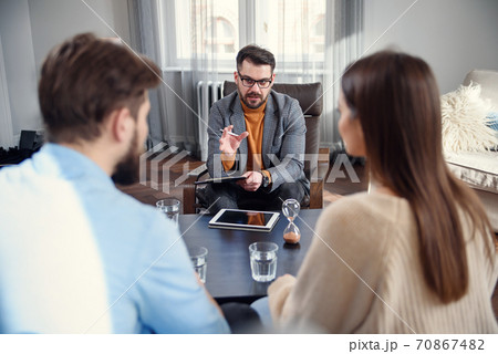 Unhappy couple arguing, having fight, disagreement at psychologists office, frustrated young family discussing relationship problems with their therapist 70867482