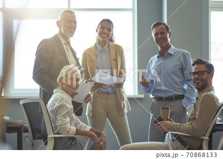 Strong and successful team. Group of happy multiracial business people smiling at camera while having a meeting at office Strong and successful team. Group of happy multiracial business people smiling at camera while having a meeting at office 70868133
