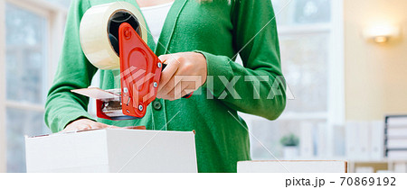 Young woman packing boxes to be shipped 70869192