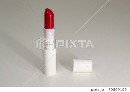 Red lipstick with a white background and cap lying next to it Red lipstick with a white background and cap lying next to it 70869196