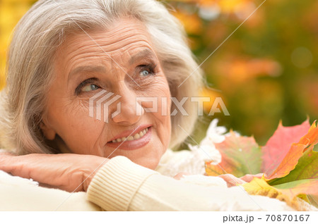 Happy senior beautiful woman in autumn park Happy senior beautiful woman in autumn park 70870167