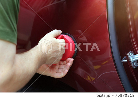 Man fixing car  dent by himself 70870518