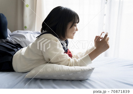 スマホを見る女子高生 70871839