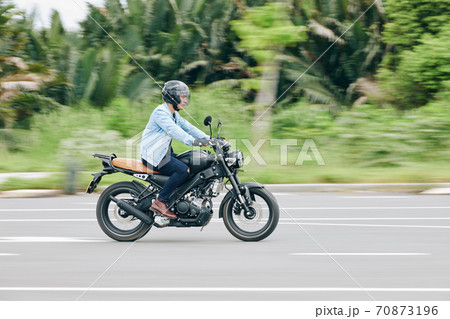 Riding fast on motorcycle 70873196