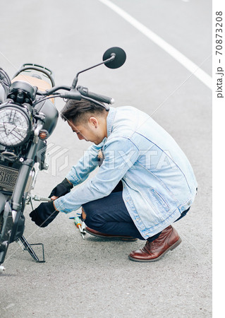 Man inspecting motorcycle 70873208