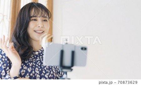 スマホで動画を撮る女性　ライバー　配信者　ユーチューバー　Vlog 70873629
