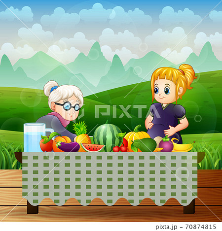Old woman and a pregnant woman with different fruits on the table 70874815
