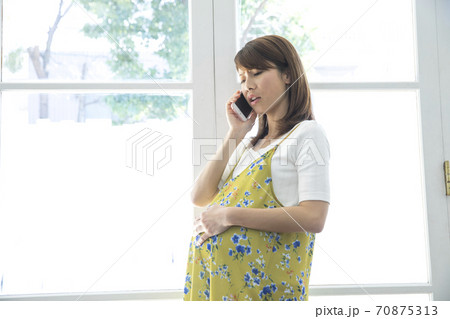 電話をする妊婦 70875313