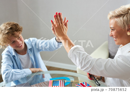 friendly english tutor and schoolboy give high five to each other 70875652