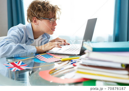 caucasian teen boy sit with laptop, studying online caucasian teen boy sit with laptop, studying online 70876187