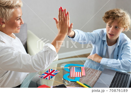happy teacher give high five to schoolboy at home happy teacher give high five to schoolboy at home 70876189