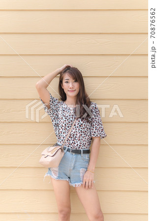 Asian women long hair wearing polka dot dress, jeans shorts Fashion shoulder bag On a wooden background 70876562