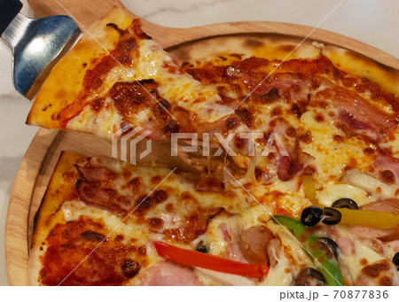 fresh piece of pizza over wooden plate 70877836