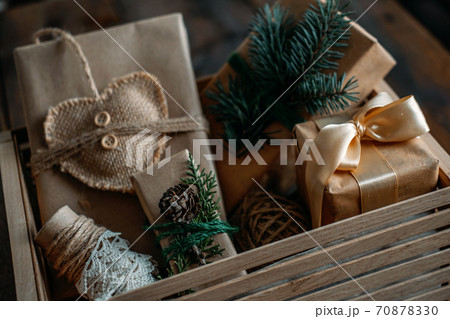 Sustainable Christmas, zero waste gifts, natural xmas decorations. Wrapping Christmas gifts in recycled brown paper in wooden care box. Vintage style Christmas packaging ideas Sustainable Christmas, zero waste gifts, natural xmas decorations. Wrapping Christmas gifts in recycled brown paper in wooden care box. Vintage style Christmas packaging ideas 70878330